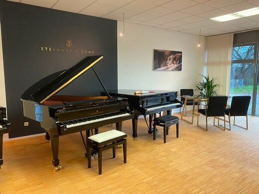 Steinway-Flügel vor dunkler Markenwand